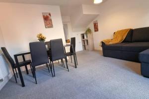 a living room with a table and chairs and a couch at A modern and spacious home. in Luton