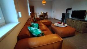 a living room with a brown leather couch and a table at "Haus Landgang" für Naturliebhaber, strandnah, ruhig, mit großem Garten in Pepelow