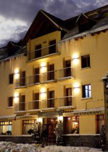 un grand bâtiment avec des lumières devant lui dans l'établissement Hotel Turrull, à Vielha e Mijaran