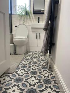 a bathroom with a toilet and a tile floor at Guest Homes - Fairlie Flat in Oxford