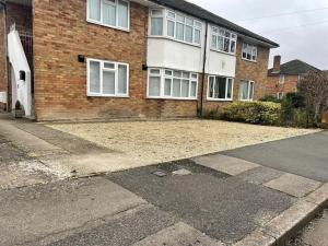 an empty driveway in front of a brick house at Guest Homes - Fairlie Flat in Oxford