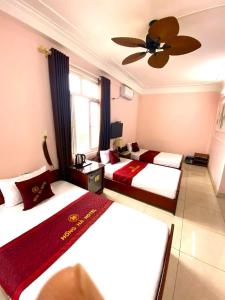 a hotel room with two beds and a ceiling fan at Hong Ha Airport Hotel in Thach Loi