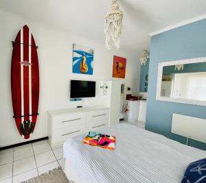 a bedroom with a bed and a surfboard on the wall at Studio@PlaneSt in Jeffreys Bay
