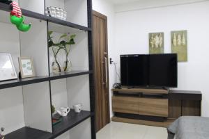 a living room with a television on a wooden entertainment center at AP 80- Apart OH in Ciudad del Este
