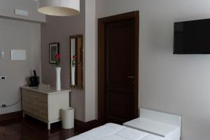 a bedroom with a bed and a dresser and a television at Affittacamere Le Dimore del Riccio in Foggia