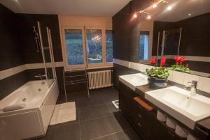 a bathroom with two sinks and a bath tub and a tub at XALET CARLEMANY (Casa entera /hab.) in Erts