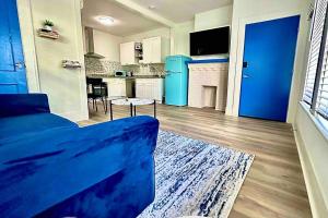 a living room with a blue couch and a kitchen at Luxury 1 Bd Montrose - Genova at The Italian Plaza in Houston