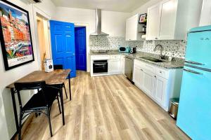 a kitchen with white cabinets and blue doors and a table at Luxury 1 Bd Montrose - Genova at The Italian Plaza in Houston