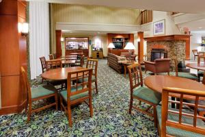 um quarto de hotel com mesas e cadeiras e uma sala de estar em Staybridge Suites Allentown Airport Lehigh Valley, an IHG Hotel em Allentown