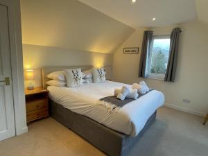 a bedroom with a large bed and a window at The Cottage, overlooking Loch Fyne in Cairndow