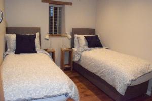 a room with two beds in a room at Dairy in the Black Mountains in Abergavenny