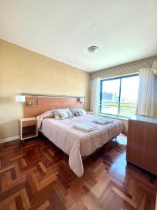 1 dormitorio con cama grande y ventana grande en Impecable, amplio y moderno departamento en la mejor ubicacion de la Ciudad de Mendoza en Mendoza