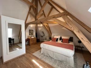 Schlafzimmer mit einem Bett in einem Zimmer mit Balken in der Unterkunft Domaine de la Course in Doudeauville