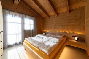 um quarto com uma cama numa parede de madeira em Chalet Gamserrugg em Wildhaus