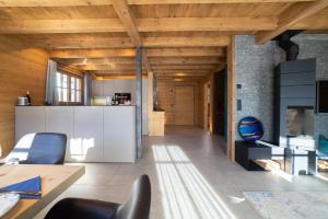a kitchen and living room with wood ceilings at Chalet Gamserrugg in Wildhaus