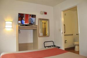 a bedroom with a bed and a tv on a wall at Motel 6-Enfield, CT - Hartford in Enfield