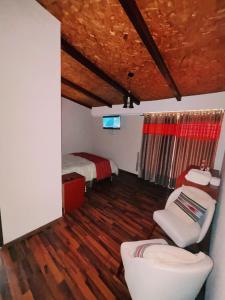 una camera con un letto e una sedia di Hotel Vista Verde a Huancayo