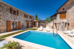 - une piscine en face d'une maison en pierre dans l'établissement Villa Zinnia, à Fabci
