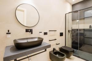 W łazience znajduje się czarna umywalka i lustro. w obiekcie Sunway Apartments w mieście Alghero