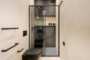 W łazience znajduje się kabina prysznicowa i czarna toaleta. w obiekcie Sunway Apartments w mieście Alghero