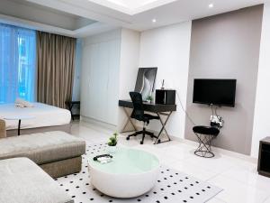 a living room with a couch and a bed and a tv at Cozy living studio , with private balcony @ Mont Kiara Hartamas in Kuala Lumpur