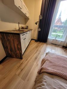 a kitchen with a sink and a wooden floor at Apartament w sercu Elbląga in Elblag