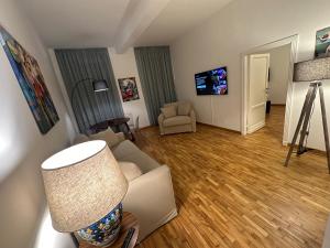 a living room with a couch and a chair and a television at House of the Sun in Trastevere in Rome