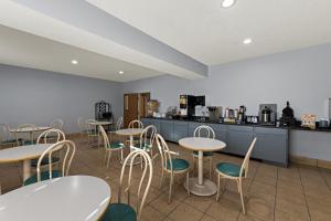 ein Restaurant mit Tischen und Stühlen und einer Theke in der Unterkunft Red Lion Inn & Suites Gretna in Gretna