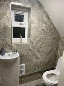 ein Badezimmer mit Waschbecken und Toilette und einem Fenster in der Unterkunft Five Oaks House- Entire 3 Bedroom House for Family & Contractors with up to 5 sleep- NO PARTIES ALLOWED in Willenhall + 29 Fotos
