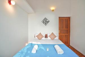 a bedroom with a blue bed with white sheets and pillows at Villa Seafront Goa in Anjuna