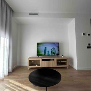 een woonkamer met een tv en een zwarte stoel bij Estrénalo a minutos de BCN in Sant Feliu de Llobregat