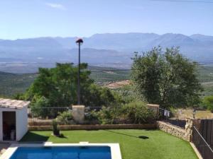 un patio trasero con piscina y césped verde en Balcón del Guadalquivir, en Baeza