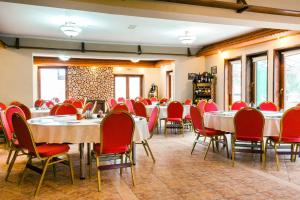 Pensiune si Restaurant Anda في جورجيني: غرفة طعام مع طاولات وكراسي حمراء