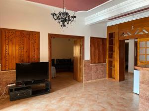 a living room with a flat screen tv on a entertainment center at Dar El fayda in Oulad Raho