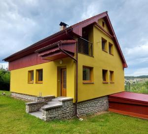 una casa amarilla y roja con techo rojo en Dům Boubín en Vimperk