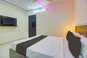 a bedroom with a bed and a tv on the wall at Super Collection O Hotel Mayur Inn in Hyderabad