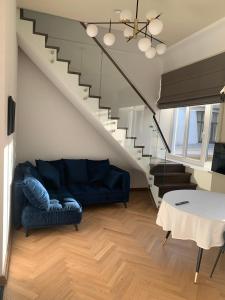 a living room with a blue couch and stairs at Kaunas Embassy Apartments in Kaunas