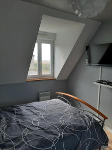 ein Schlafzimmer mit einem Bett im Dachgeschoss in der Unterkunft Gîte Cap Goéland - Maison chaleureuse au cœur du site des 2 Caps in Audinghen