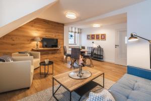 un soggiorno con un divano e un tavolo di Das Landhaus Apartments Prägant a Bad Kleinkirchheim