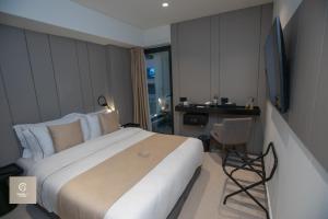 ティラナにあるCentral Inn Hotelの大きなベッドとデスクが備わるホテルルームです。