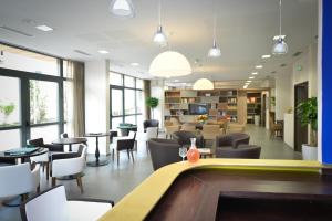 a waiting room with tables and chairs and a library at Résidence de Maisons-Laffitte in Maisons-Laffitte