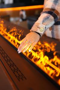 osoba z ręką na stole z ogniem w obiekcie Style Hotel Grifone w Madonna di Campiglio