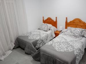 dos camas sentadas una al lado de la otra en una habitación en Apartamentos los carros 2, en Guadix
