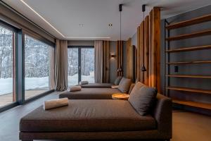 a living room with two couches and a large window at Chalet VIE in Viehhofen