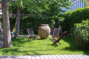 ミラノにあるSTUDIO GINKO - Cozy studio for travel and workの椅子2脚、芝生に座る大花瓶
