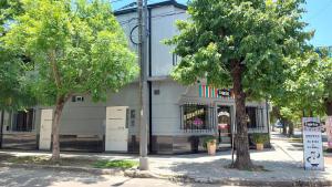 a store on the corner of a street with two trees at Departamento monoambiente Necco Apart in Corrientes