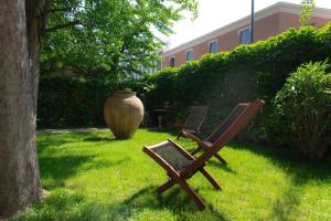 ミラノにあるSTUDIO GINKO - Cozy studio for travel and workの花瓶の横の芝生に座る椅子2脚