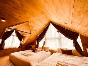 1 dormitorio con 2 camas en una habitación de madera en Quỳnh Hoa Hotel Tam Đảo en Tam Ðảo