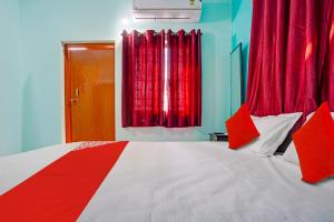 una camera da letto con un grande letto con tende rosse di OYO Hotel R R a Nagpur