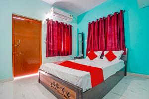 a bedroom with a bed with red curtains and a red door at OYO Hotel R R in Nagpur